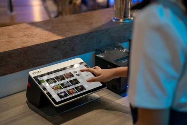 A close-up of a person interacting with a touchscreen in a restaurant setting, showcasing modern technology.