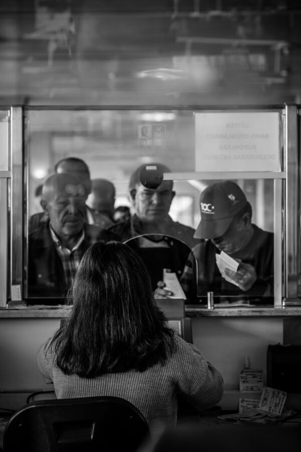 Black and white photo of people at a ticket counter in Ankara, Türkiye.